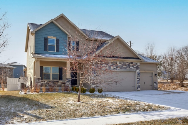 craftsman inspired home with covered porch, an attached garage, stone siding, and concrete driveway