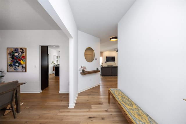 hall with baseboards and light wood-style floors