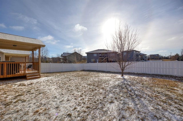 view of yard featuring a residential view, a fenced backyard, and a deck