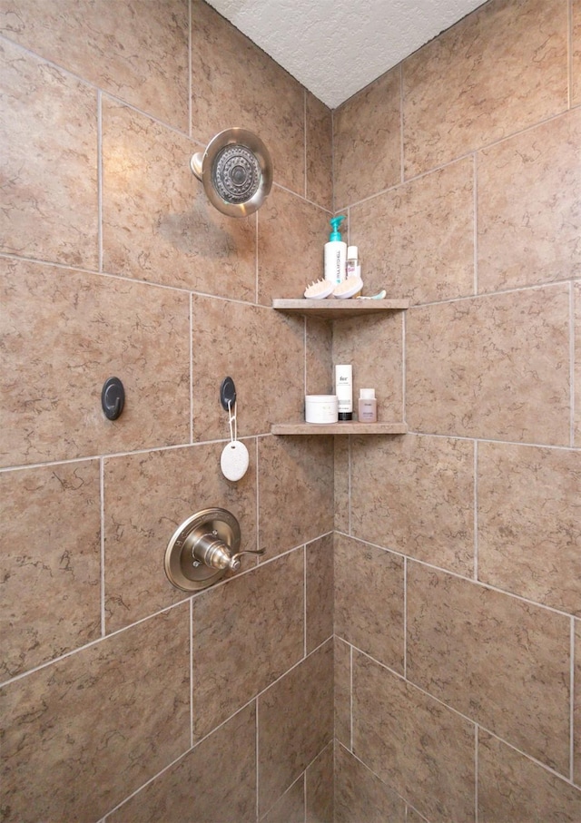 room details featuring a tile shower and a textured ceiling