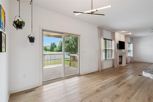 16924 Prairie Dr, Clive, IA 50325 - unfurnished living room featuring light wood finished floors, a fireplace with flush hearth, and ceiling fan
