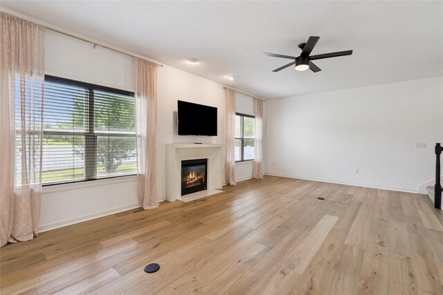 16924 Prairie Dr, Clive, IA 50325 - unfurnished living room featuring a fireplace with flush hearth, a ceiling fan, and light wood finished floors