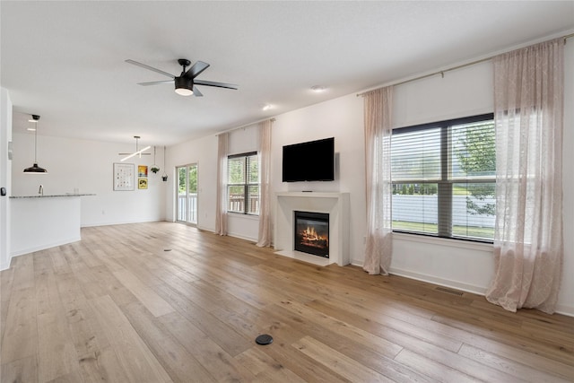 16924 Prairie Dr, Clive, IA 50325 - unfurnished living room featuring a fireplace with flush hearth, ceiling fan, and light wood finished floors