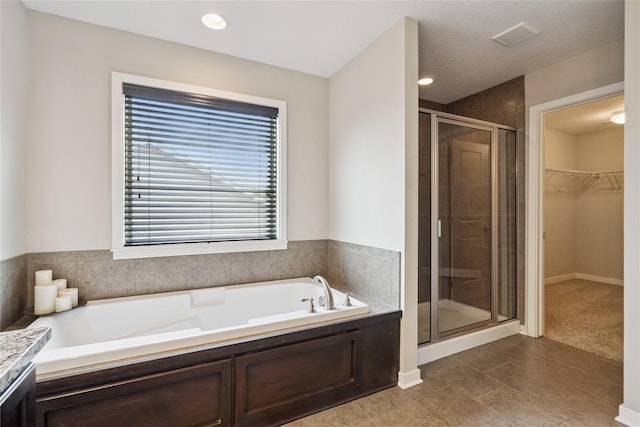 16924 Prairie Dr, Clive, IA 50325 - full bathroom featuring a stall shower, a garden tub, a walk in closet, tile patterned flooring, and vanity