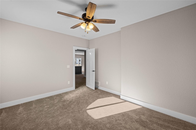 carpeted spare room featuring ceiling fan