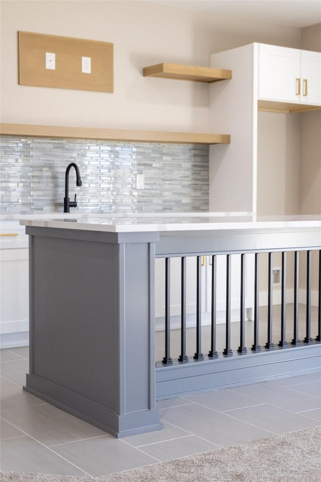 interior space with white cabinetry, tasteful backsplash, and light tile patterned floors