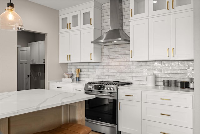 kitchen with white cabinetry, wall chimney range hood, hanging light fixtures, and stainless steel range with gas stovetop