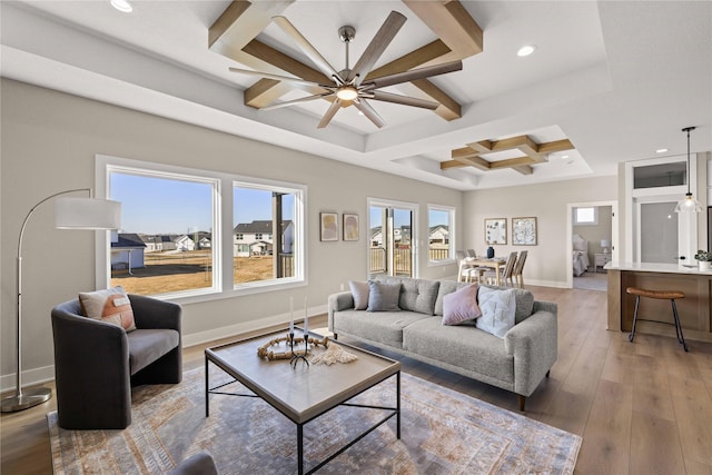 living room featuring beamed ceiling, a healthy amount of sunlight, coffered ceiling, and wood-type flooring