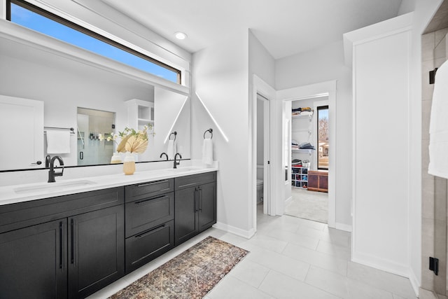 bathroom with a sink, toilet, double vanity, and a shower stall