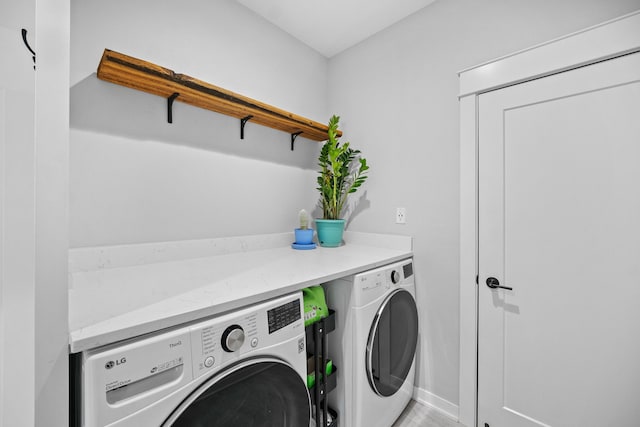 laundry area with baseboards, laundry area, and washer and clothes dryer