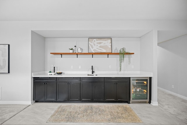 bar with wine cooler, indoor wet bar, baseboards, and a sink