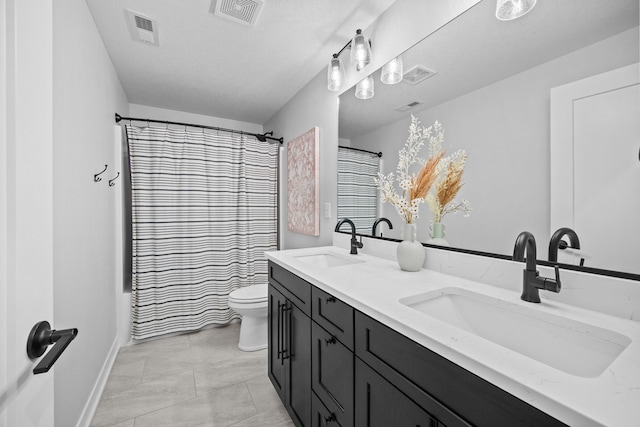 full bath with toilet, visible vents, and a sink