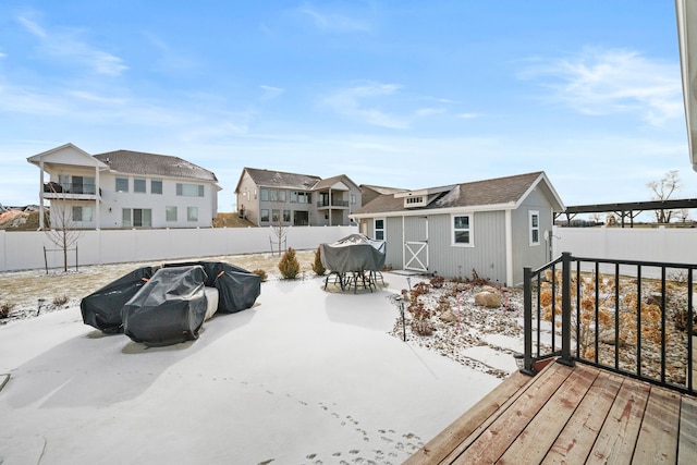 exterior space with outdoor dining area, a residential view, an outbuilding, and a fenced backyard