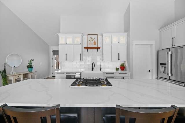 kitchen with white cabinetry, sink, a kitchen breakfast bar, and appliances with stainless steel finishes