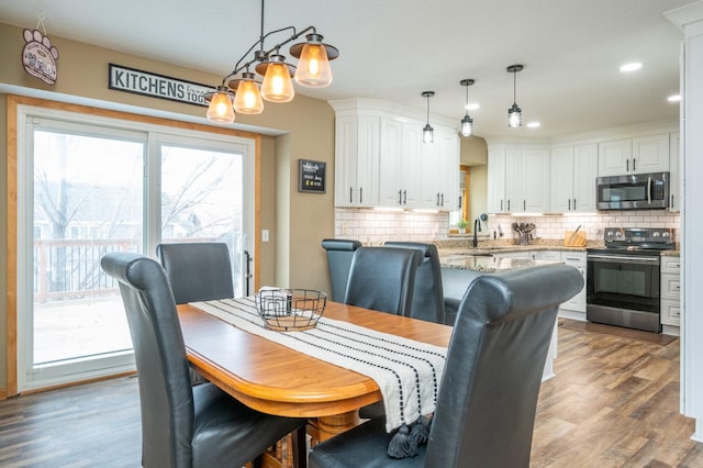 dining space with recessed lighting and wood finished floors