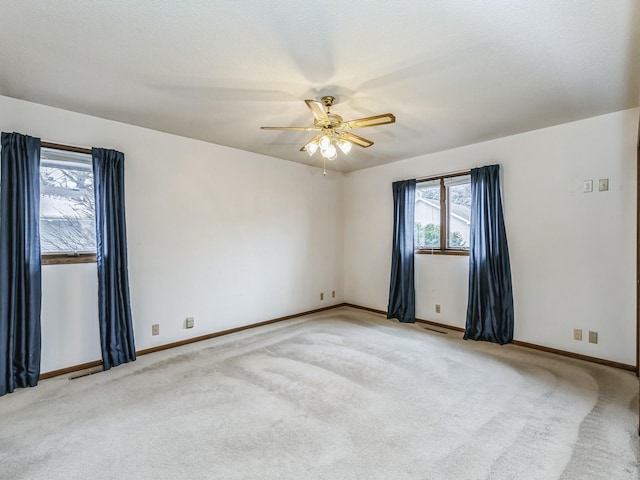 unfurnished room featuring light carpet, ceiling fan, and baseboards