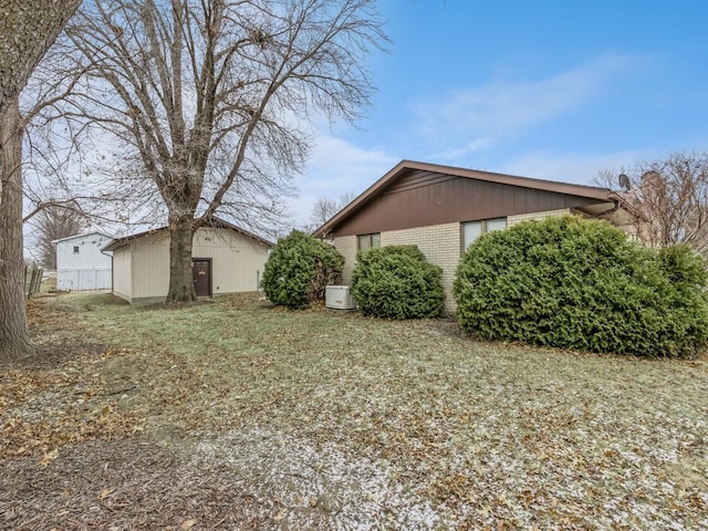 view of side of home featuring brick siding and a lawn