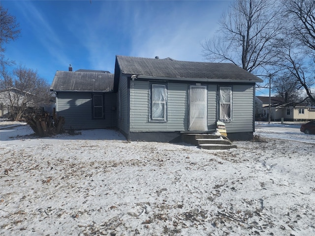 view of snow covered rear of property