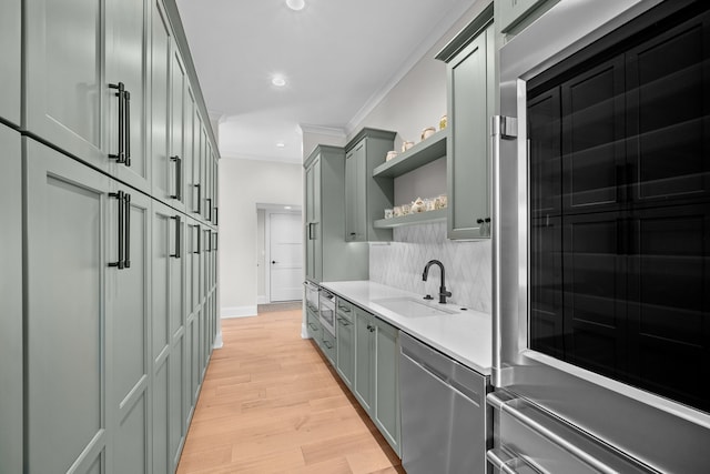 bar featuring sink, crown molding, light hardwood / wood-style flooring, backsplash, and stainless steel appliances