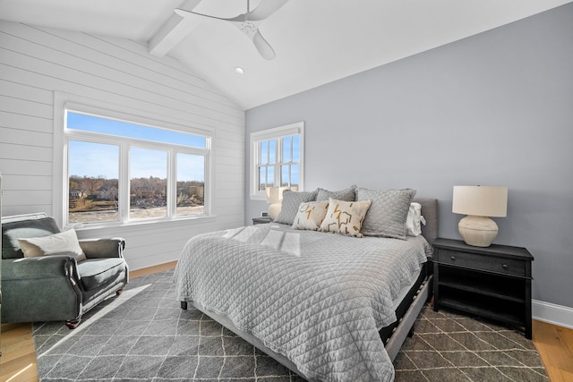 bedroom featuring lofted ceiling with beams, dark hardwood / wood-style flooring, wooden walls, and ceiling fan