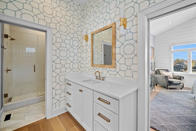 bathroom featuring lofted ceiling, wood-type flooring, an enclosed shower, and vanity