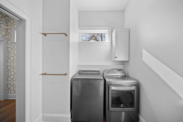 laundry area with cabinets, hardwood / wood-style flooring, and washer and dryer