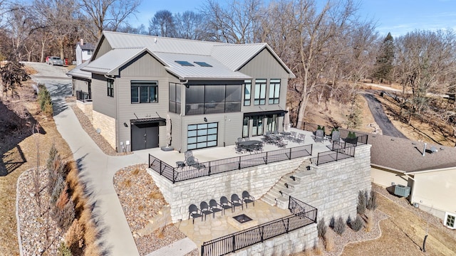 rear view of house featuring a sunroom and a patio area