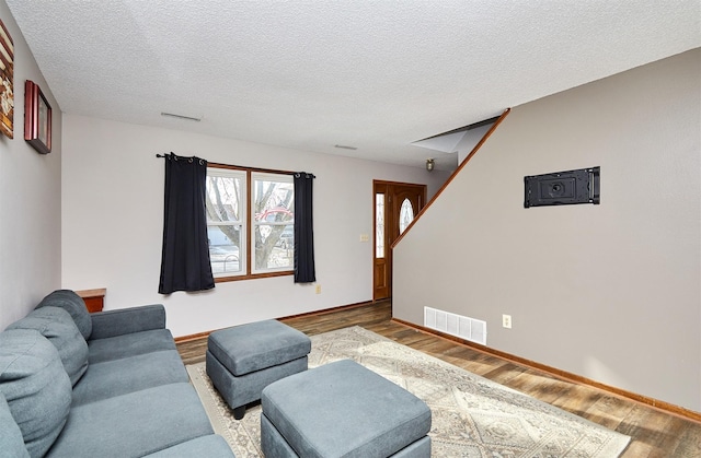 living room with a textured ceiling and light wood-type flooring