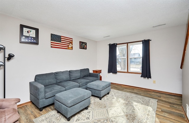 living room with wood-type flooring and a textured ceiling