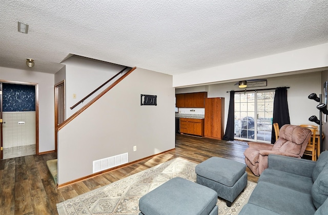 living room featuring dark hardwood / wood-style floors and a textured ceiling