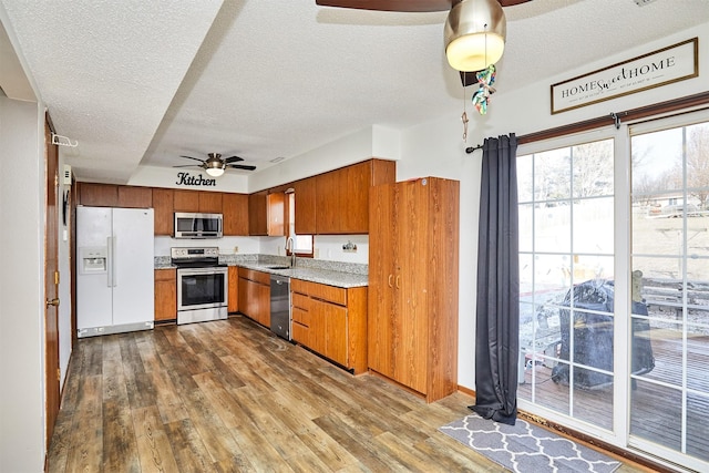 kitchen featuring sink, dark wood-type flooring, ceiling fan, appliances with stainless steel finishes, and a textured ceiling