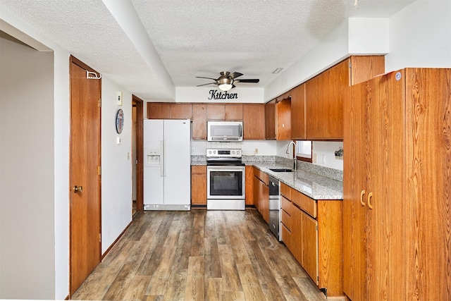 kitchen featuring stainless steel appliances, dark hardwood / wood-style flooring, sink, and a textured ceiling