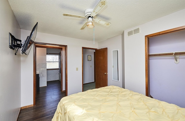 bedroom with dark wood-type flooring, ceiling fan, a closet, and a textured ceiling