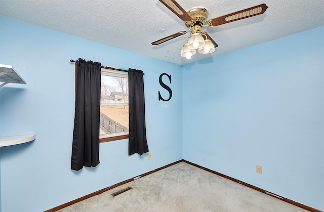 carpeted spare room with ceiling fan and a textured ceiling