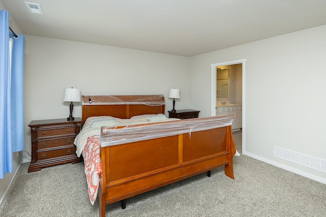 bedroom featuring connected bathroom and light colored carpet