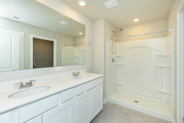 bathroom featuring a shower and vanity