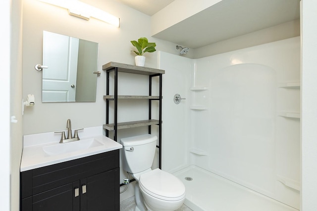 bathroom with walk in shower, vanity, and toilet