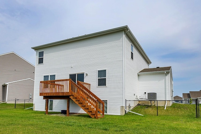 rear view of house featuring central AC unit, a lawn, and a deck