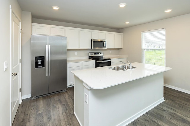 kitchen with white cabinetry, appliances with stainless steel finishes, sink, and a center island with sink