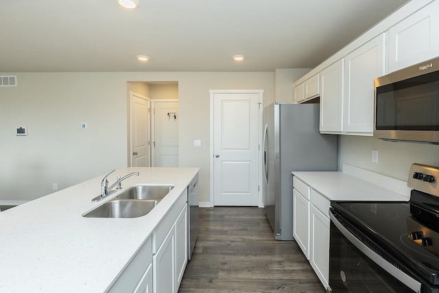 kitchen featuring sink, appliances with stainless steel finishes, white cabinetry, dark hardwood / wood-style floors, and light stone countertops