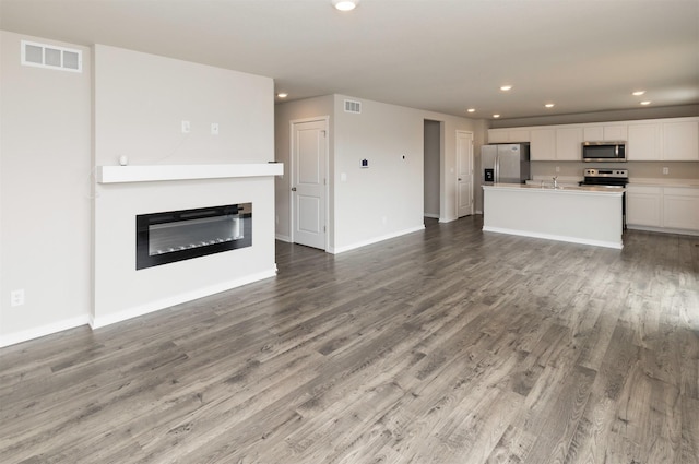 unfurnished living room featuring visible vents, recessed lighting, and wood finished floors