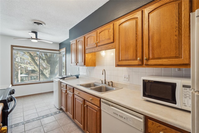 kitchen featuring light tile patterned flooring, sink, ceiling fan, white appliances, and backsplash