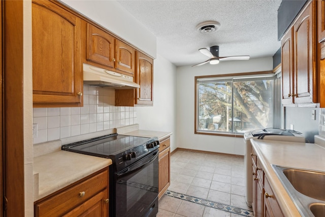 kitchen featuring sink, light tile patterned floors, electric range, ceiling fan, and a textured ceiling