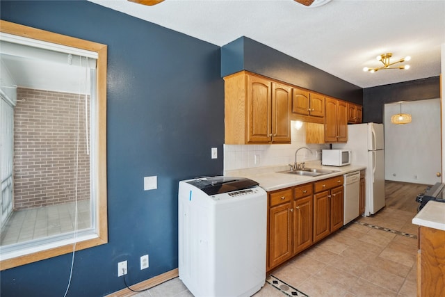 kitchen featuring tasteful backsplash, sink, white appliances, and light tile patterned floors