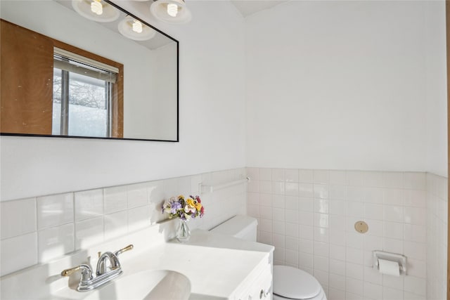 bathroom featuring tile walls, vanity, and toilet