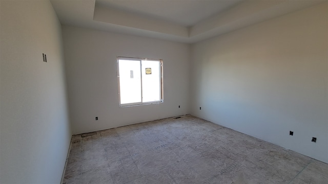 unfurnished room featuring a tray ceiling