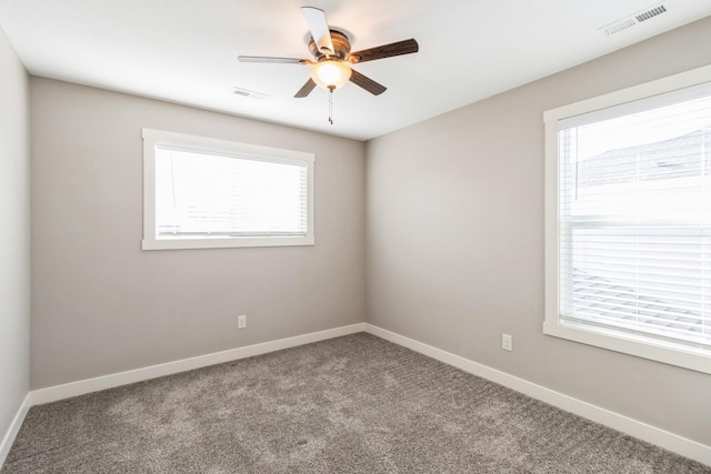 empty room with plenty of natural light, ceiling fan, and carpet flooring