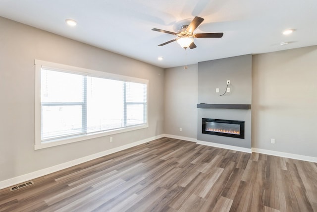 unfurnished living room with hardwood / wood-style floors and ceiling fan