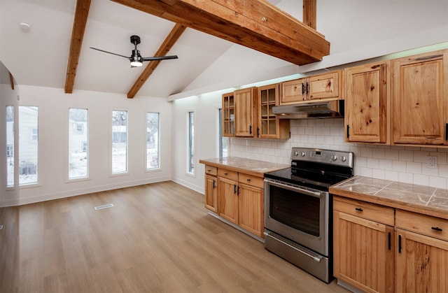 kitchen with lofted ceiling with beams, stainless steel range with electric cooktop, backsplash, ceiling fan, and light hardwood / wood-style floors