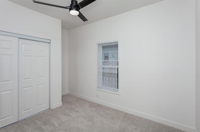 unfurnished bedroom featuring light carpet, a closet, and ceiling fan